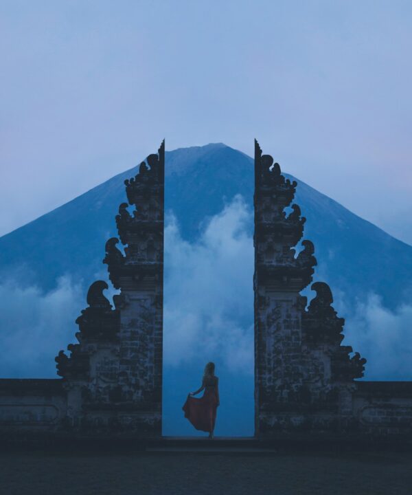 woman in between on concrete landmarks near white clouds